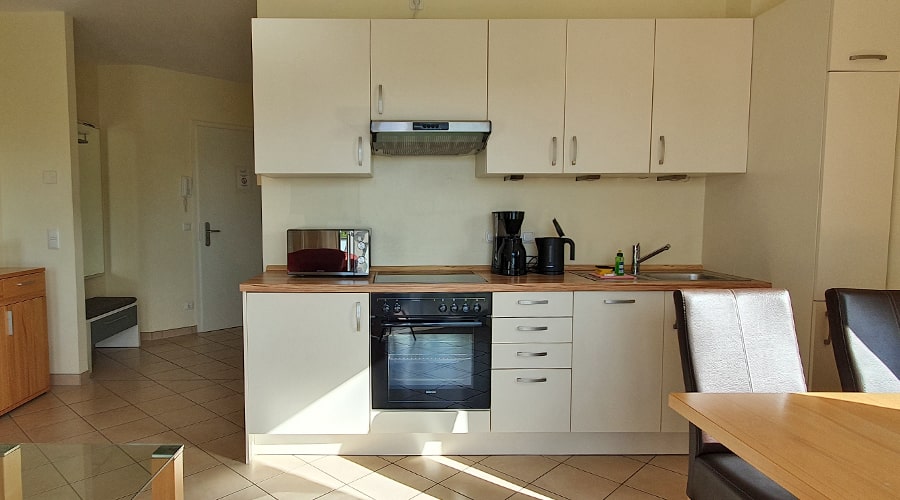 Balkon mit Tisch, Stühlen und Blick auf Ferienwohnungen